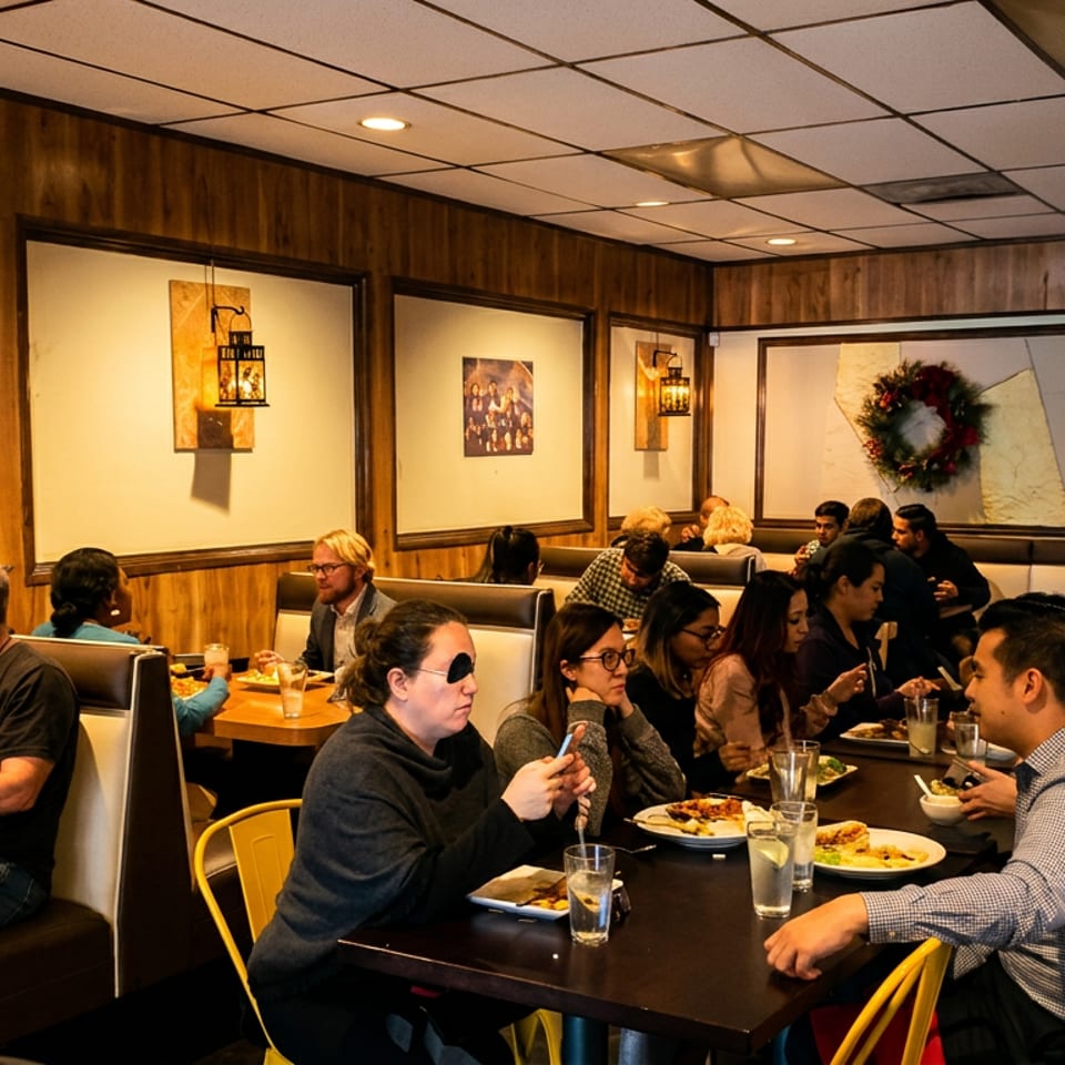Diners enjoying meals in a bustling restaurant with wood-paneled walls and festive decor.