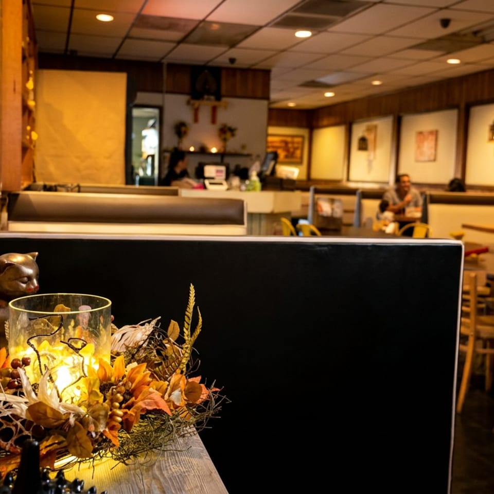 Restaurant interior with a decorative centerpiece, booths, and patrons dining at tables.